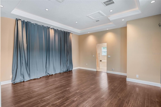 unfurnished room featuring ornamental molding, a textured ceiling, a raised ceiling, and dark hardwood / wood-style flooring