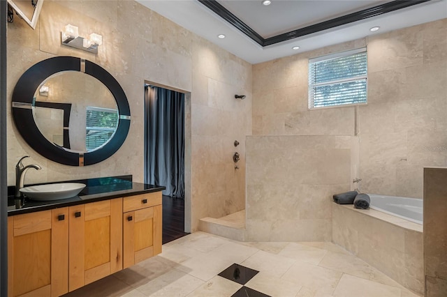 bathroom with tile walls, independent shower and bath, and vanity