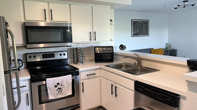 kitchen with appliances with stainless steel finishes, decorative backsplash, and white cabinetry