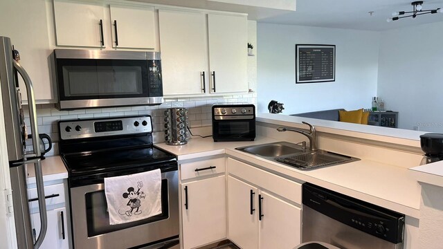 kitchen featuring light countertops, backsplash, a sink, white cabinetry, and stainless steel appliances