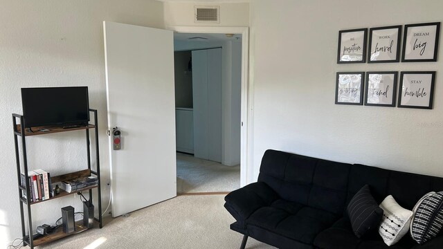 living area featuring visible vents and carpet flooring