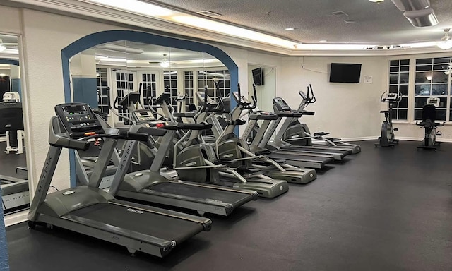 gym featuring a textured ceiling and a tray ceiling