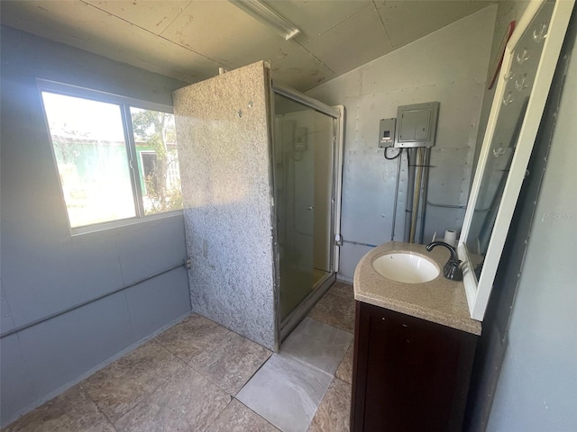 bathroom featuring vanity, a shower with shower door, and lofted ceiling