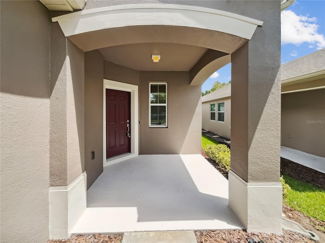 entrance to property featuring stucco siding