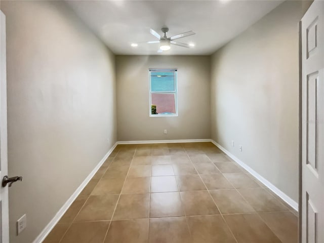 tiled spare room with ceiling fan