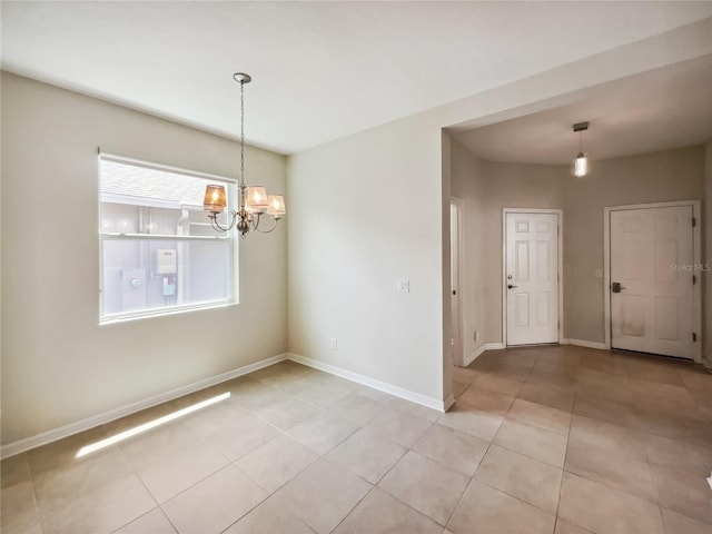 spare room featuring a chandelier, baseboards, and light tile patterned flooring