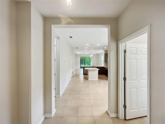 hall featuring light tile patterned floors, recessed lighting, baseboards, and visible vents