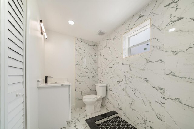 bathroom featuring vanity, toilet, and a shower