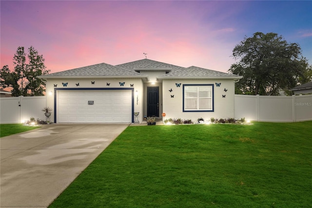 view of front of home with a lawn and a garage