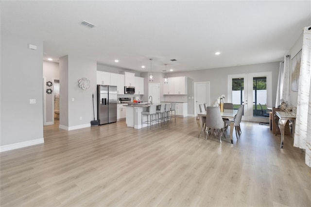 interior space with french doors, sink, and light hardwood / wood-style floors