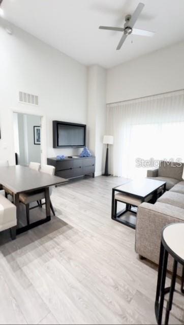 living room with light hardwood / wood-style flooring and ceiling fan