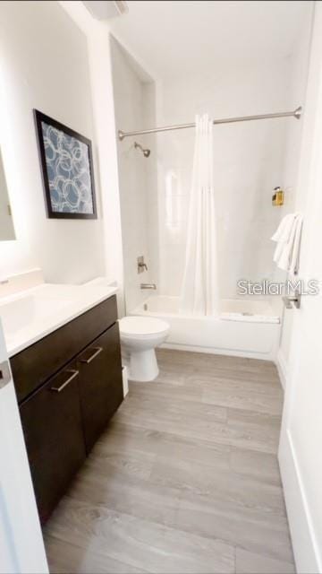 full bathroom with vanity, toilet, hardwood / wood-style flooring, and shower / bath combo