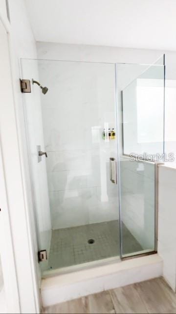 bathroom with an enclosed shower and wood-type flooring