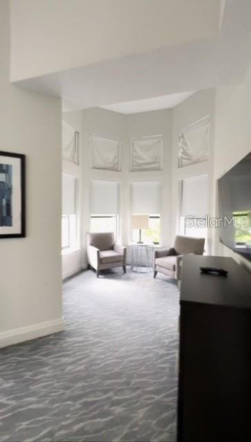 living room featuring plenty of natural light and dark colored carpet