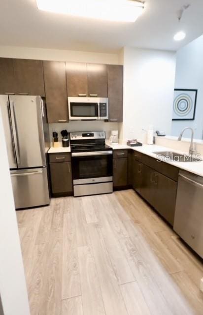 kitchen with light hardwood / wood-style flooring, appliances with stainless steel finishes, and sink