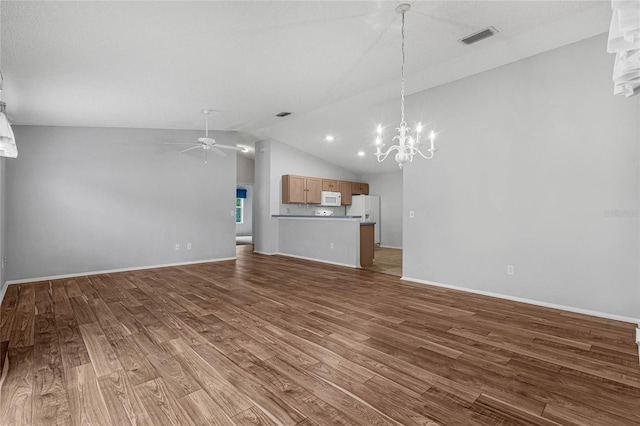 unfurnished living room with ceiling fan with notable chandelier, light wood-type flooring, and lofted ceiling