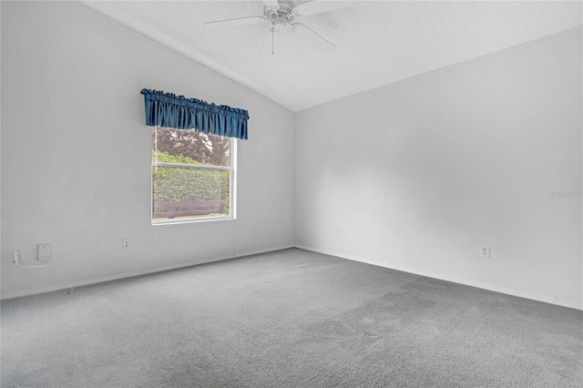 spare room with vaulted ceiling, a textured ceiling, ceiling fan, and carpet