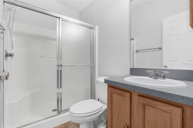 bathroom with toilet, a shower with door, a textured ceiling, and vanity