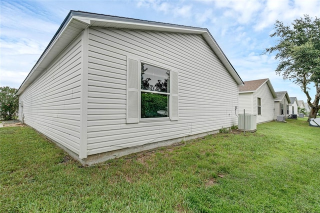 view of property exterior with central AC and a lawn