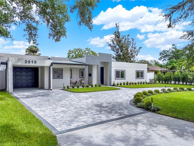 view of front of home with a garage and a front lawn