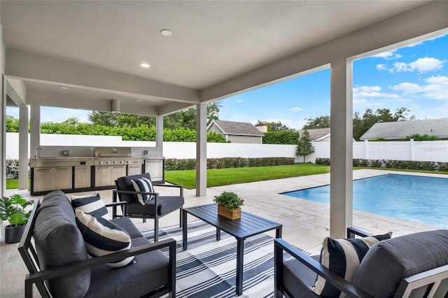 view of swimming pool with an outdoor living space, a patio area, an outdoor kitchen, and grilling area