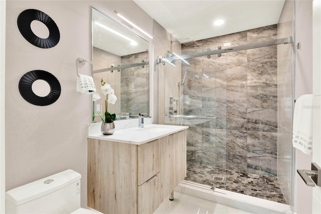 bathroom featuring vanity, a shower with shower door, tile patterned floors, and toilet