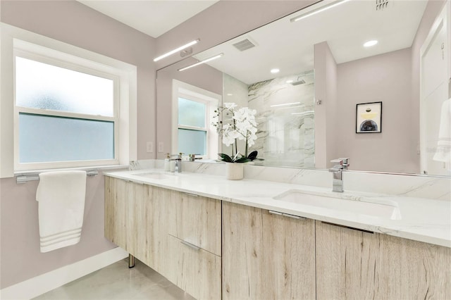 bathroom with tiled shower and vanity