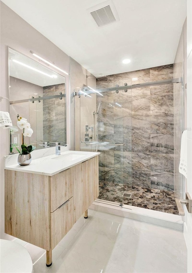 bathroom with vanity, a shower with shower door, and tile patterned floors