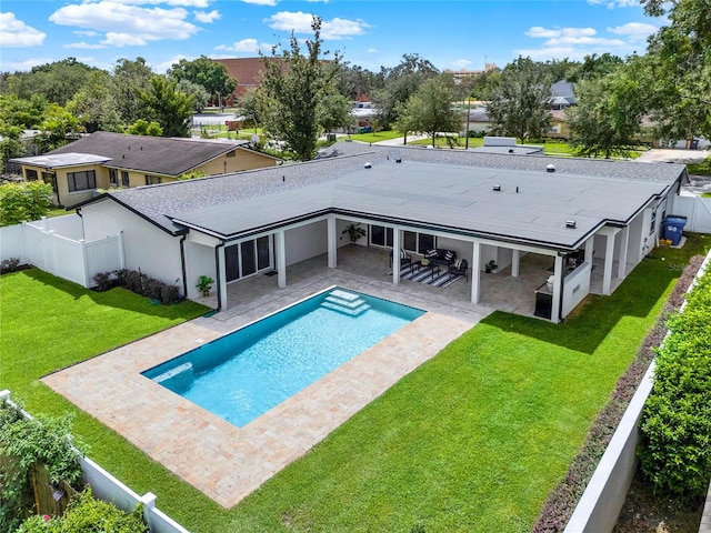 back of house with a fenced in pool, a patio area, and a lawn