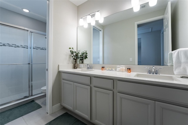 bathroom with tile patterned floors, vanity, toilet, and a shower with door