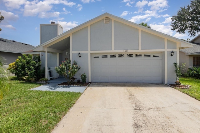 view of front facade with stucco siding, driveway, a chimney, and a garage