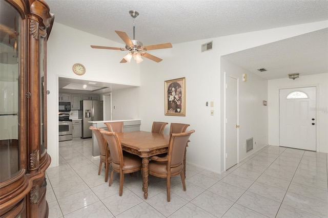 dining room with vaulted ceiling, a textured ceiling, and ceiling fan