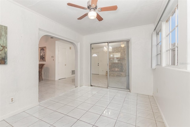 tiled spare room featuring ceiling fan and crown molding