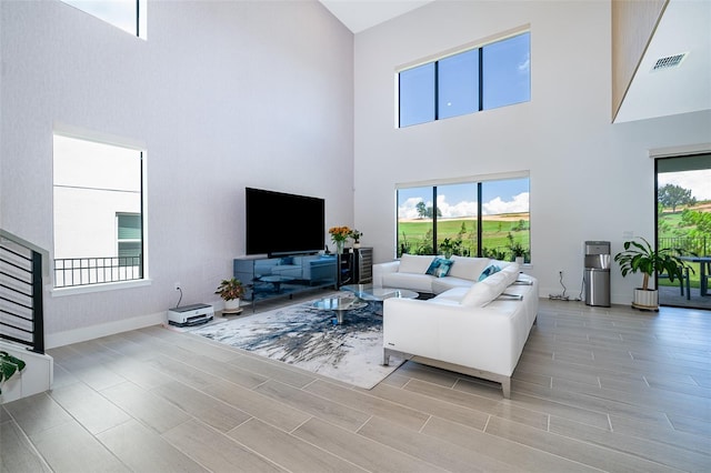 living room featuring a towering ceiling and a healthy amount of sunlight