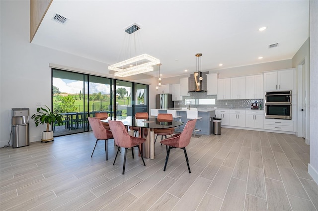 dining space featuring light wood-type flooring and a chandelier