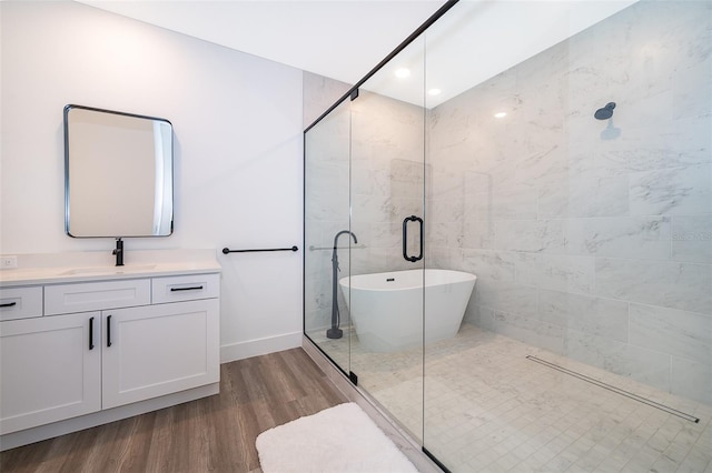 bathroom with vanity, hardwood / wood-style flooring, and plus walk in shower