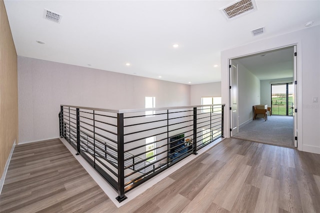 hall featuring light wood-type flooring and a healthy amount of sunlight