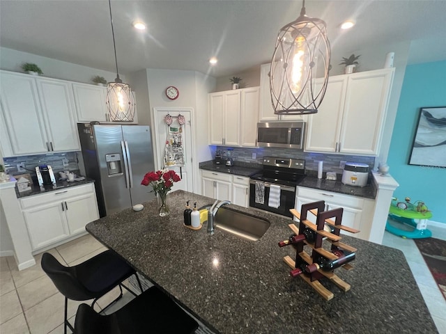 kitchen featuring appliances with stainless steel finishes, white cabinets, and pendant lighting