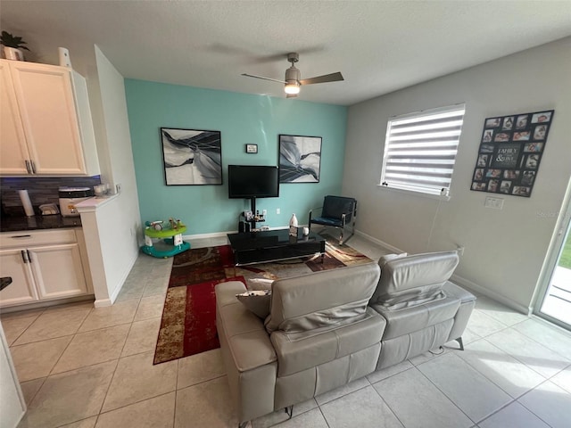 tiled living room with a textured ceiling and ceiling fan