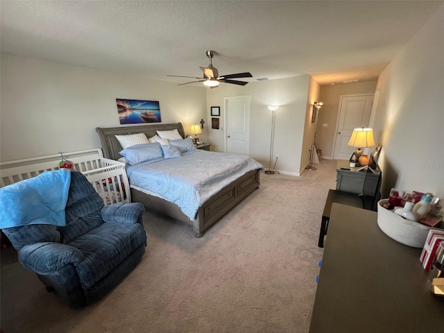 bedroom featuring ceiling fan, light carpet, and a textured ceiling