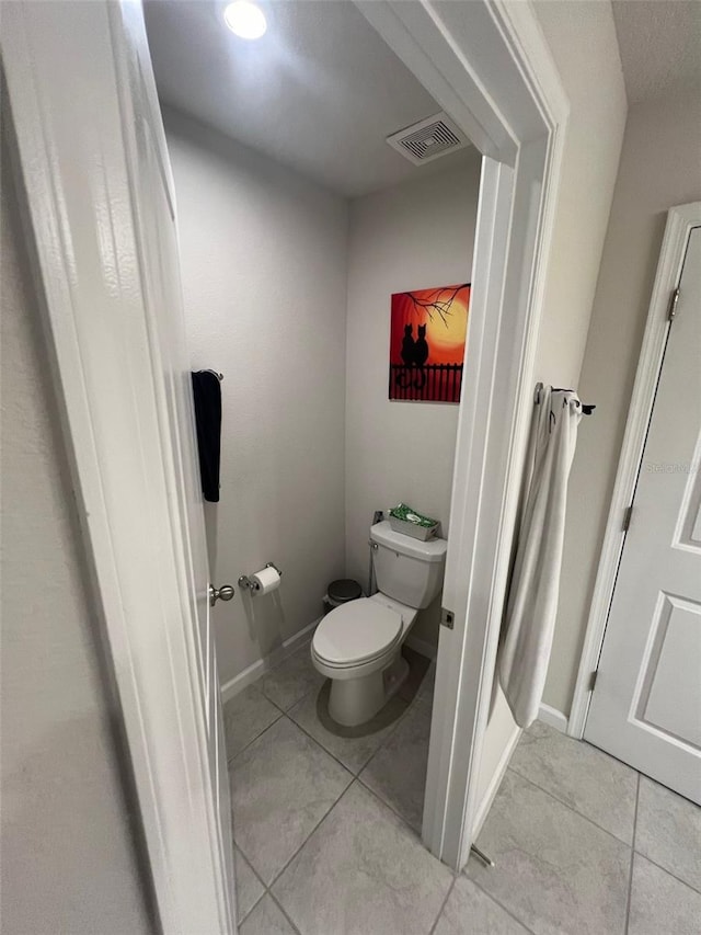 bathroom featuring toilet and tile patterned flooring