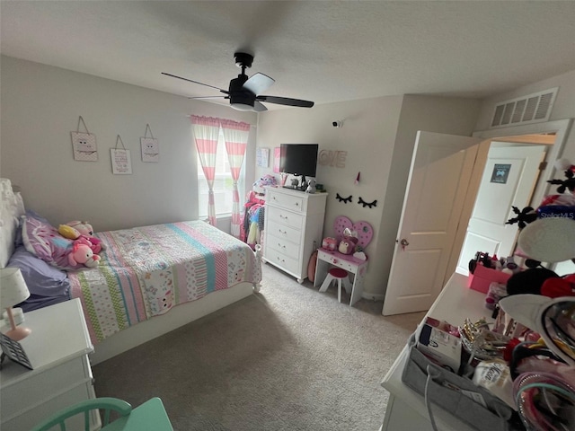 carpeted bedroom featuring ceiling fan and a textured ceiling