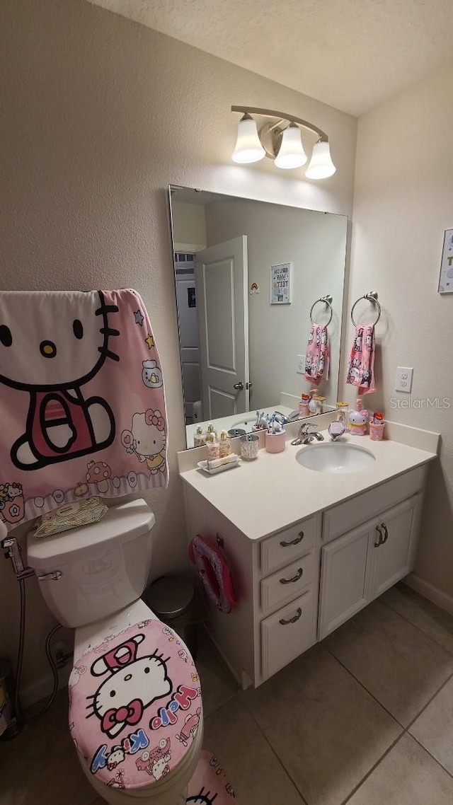 bathroom with vanity, toilet, and tile patterned floors