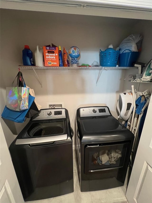 washroom with tile patterned flooring and washer and clothes dryer