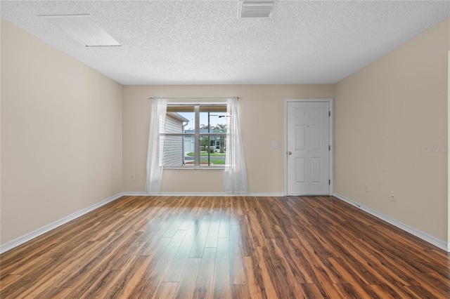 unfurnished room featuring dark wood-type flooring and a textured ceiling