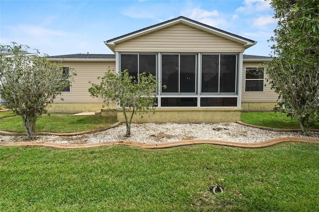 back of house with a sunroom and a yard