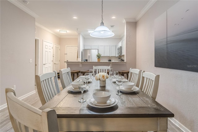 dining area with light wood-type flooring and crown molding