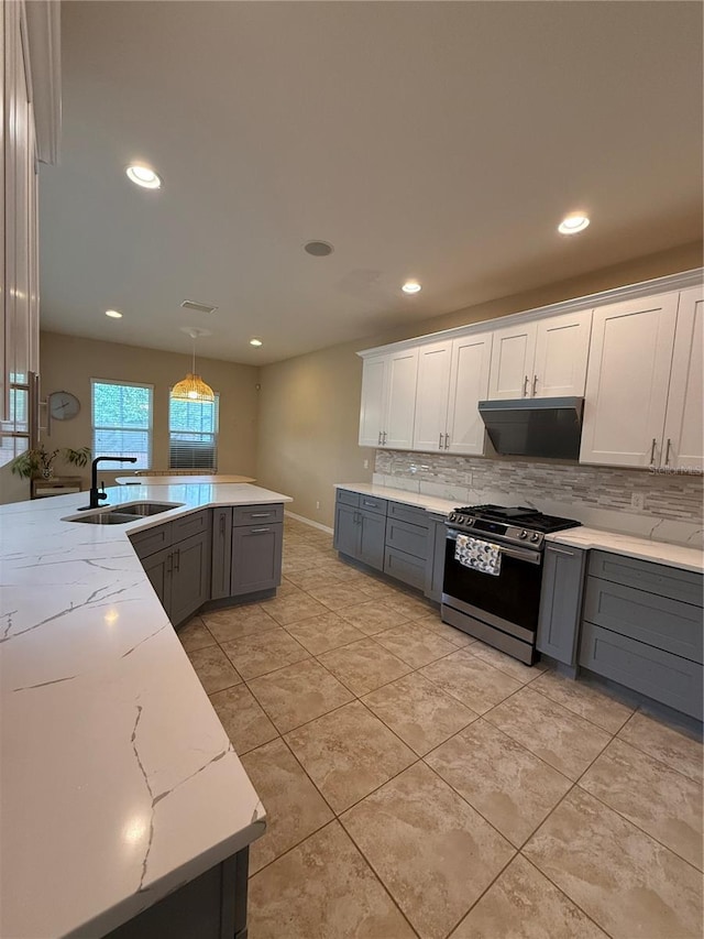 kitchen featuring white cabinets, pendant lighting, sink, tasteful backsplash, and gas range