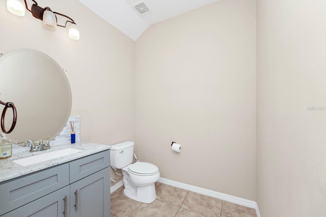 bathroom with tile patterned flooring, vanity, vaulted ceiling, and toilet