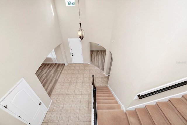 foyer entrance featuring a towering ceiling and light tile patterned flooring